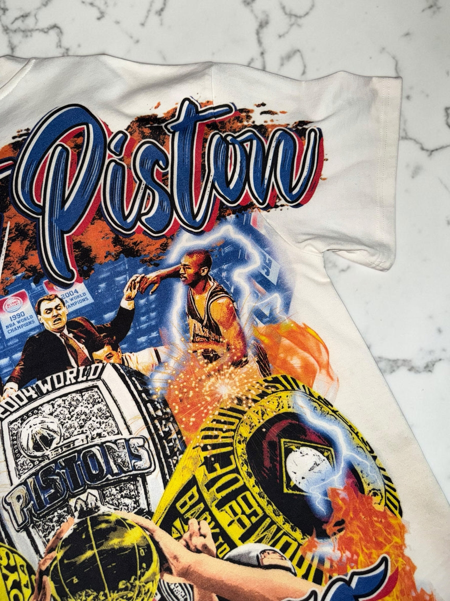 DRIPPING IN VINTY off-white Detroit Pistons graphic t-shirt featuring vintage championship rings and basketball art