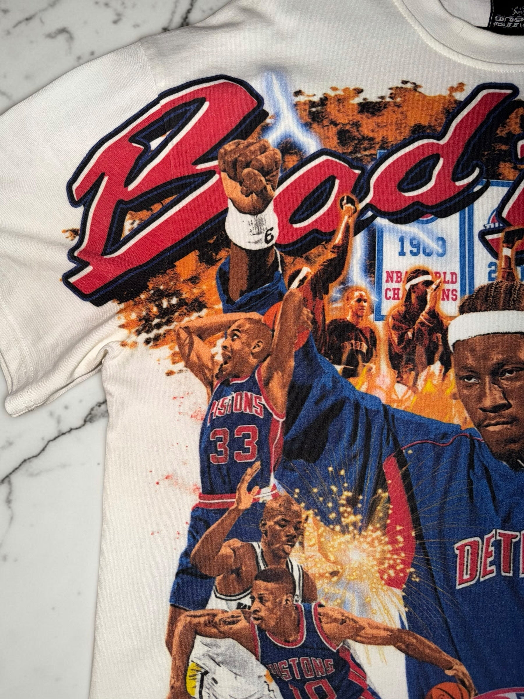 DRIPPING IN VINTY off-white Detroit Pistons Bad Boys era graphic t-shirt with vibrant basketball action print