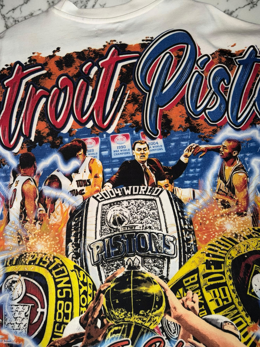DRIPPING IN VINTY off-white Detroit Pistons graphic t-shirt featuring vintage championship rings and team history