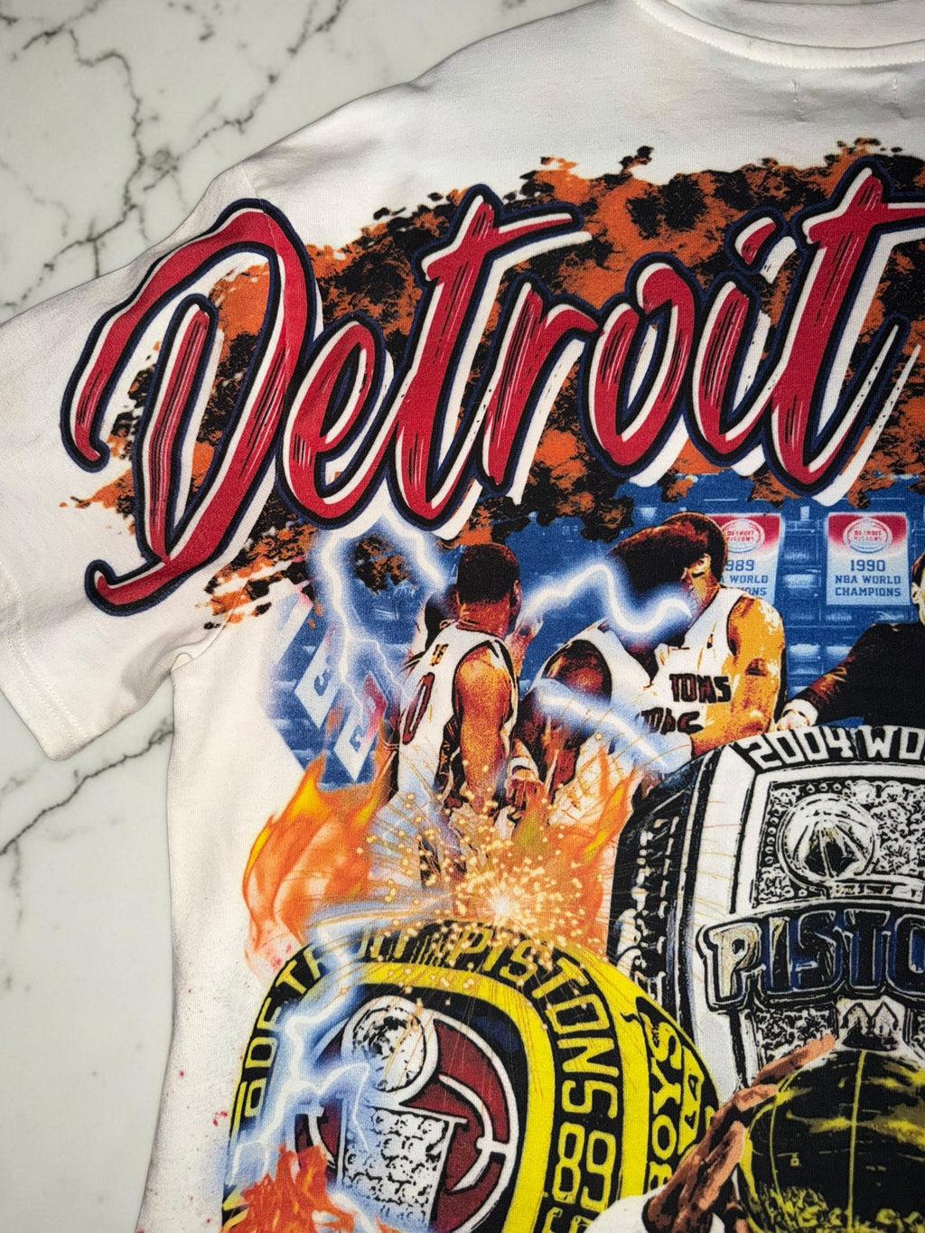 DRIPPING IN VINTY off-white Detroit Pistons vintage graphic t-shirt featuring championship rings and basketball players