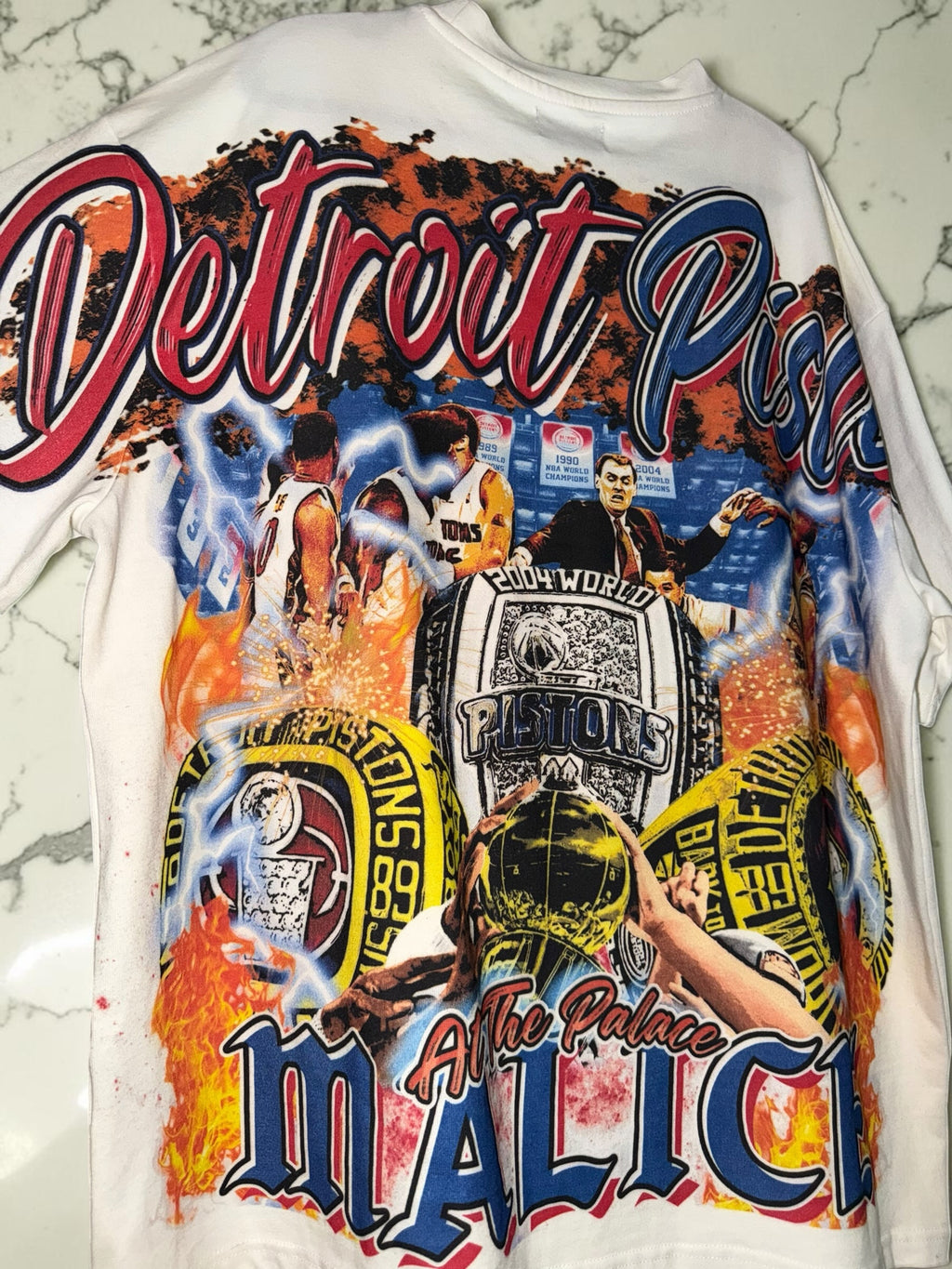 DRIPPING IN VINTY off-white Detroit Pistons vintage style graphic t-shirt featuring championship rings and team history