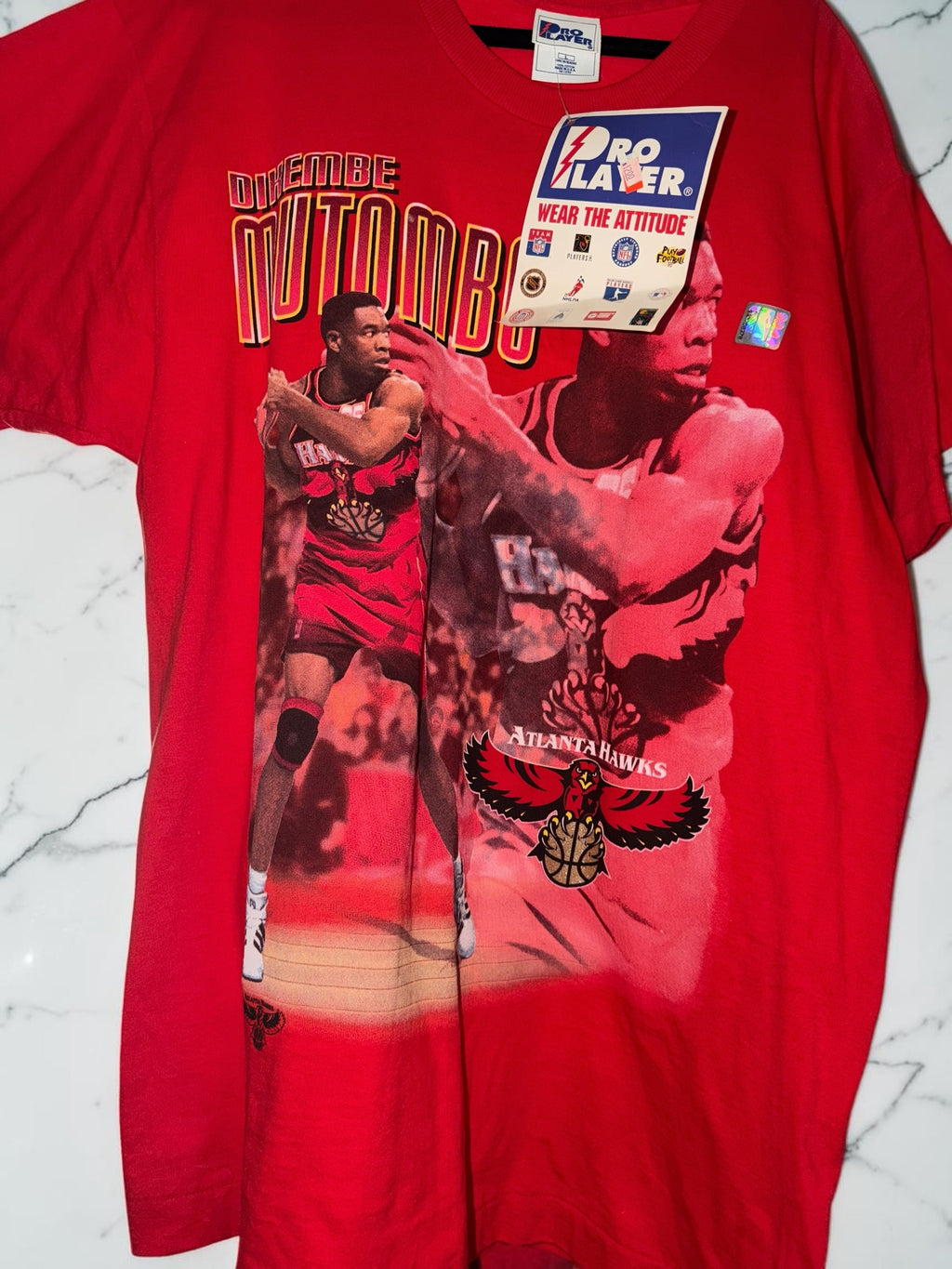 DRIPPING IN VINTY red cotton t-shirt featuring a vintage Dikembe Mutombo Atlanta Hawks graphic and Pro Player tag.
