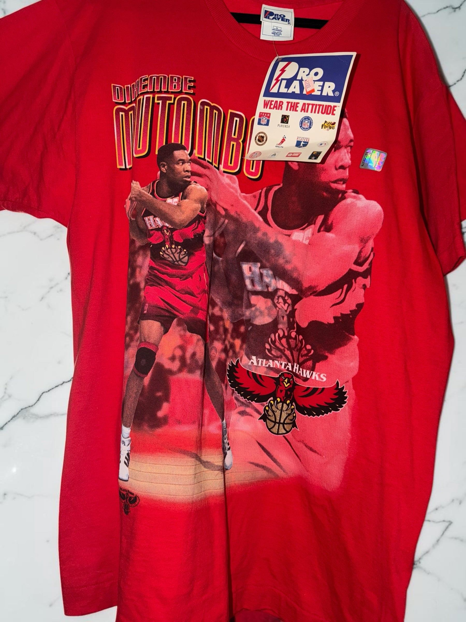 DRIPPING IN VINTY red cotton t-shirt featuring a vintage Dikembe Mutombo Atlanta Hawks graphic and Pro Player tag.